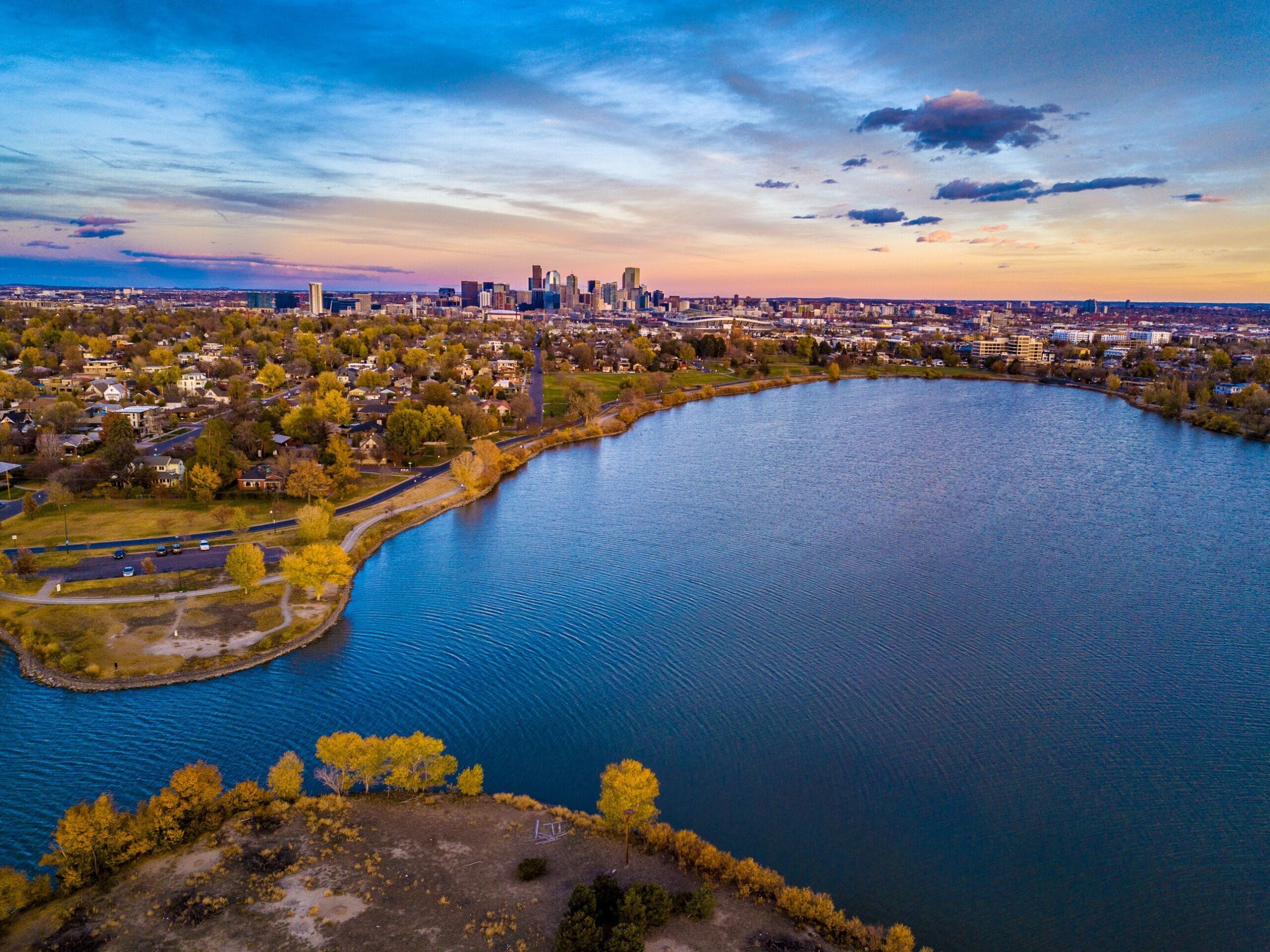 Family photos at Sloan's Lake Park Denver with downtown skyline sunset